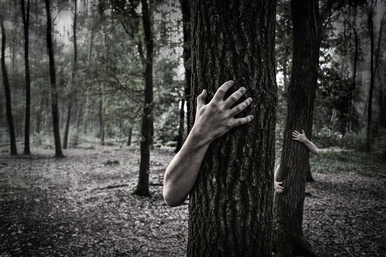 Zombie hands wrapping around tree trunks