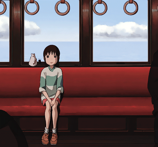 Chihiro offers No Face -- who is off-screen -- a seat on the train in Spirited Away. 